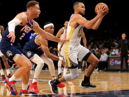 Stephen Curry, perseguido por Griffin y Brown en el partido entre los Nets y los Warriors.