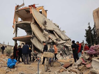 Un grupo de palestinos observa este jueves los destrozos en un edificio bombardeado por Israel en Jan Yunis, en el sur de Gaza.