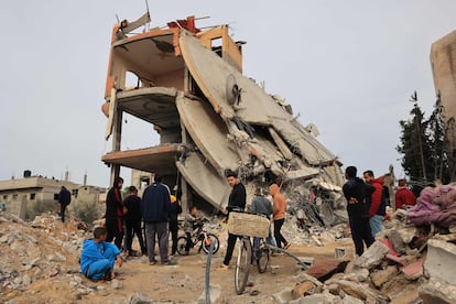 Un grupo de palestinos observa este jueves los destrozos en un edificio bombardeado por Israel en Jan Yunis, en el sur de Gaza.