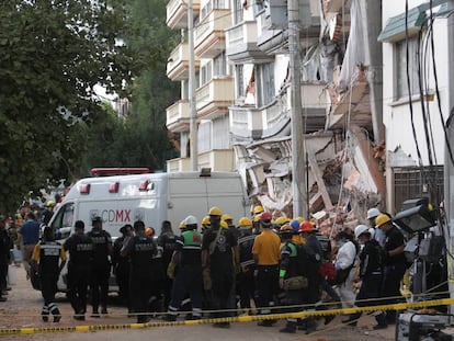 Una ambulancia forense traslada un cuerpo rescatado de un edificio colapsado.