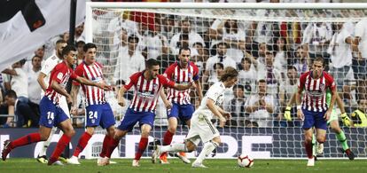 El centrocampista croata, Modric, en un intento de tiro a puerta presionado por los jugadores del Atlético de Madrid.