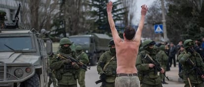 Un hombre ucranio protesta frente a soldados sin identificar y que hacen guardia en Balaklava, a las afueras de Sebastopol, en Ucrania.