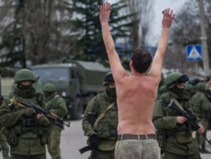 Un hombre ucranio protesta frente a soldados sin identificar y que hacen guardia en Balaklava, a las afueras de Sebastopol, en Ucrania. 