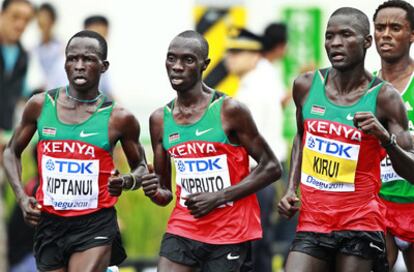 Abel Kirui (i.) y Vincent Kipruto, oro y plata, junto a su compatriota Kiptanui (d.).