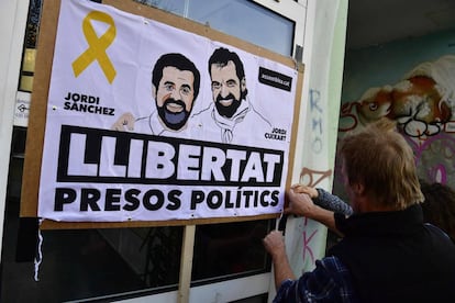 Un hombre coloca una pancarta con los rostros de Jordi Sànchez y Jordi Cuixart en Berlín el 7 de abril.