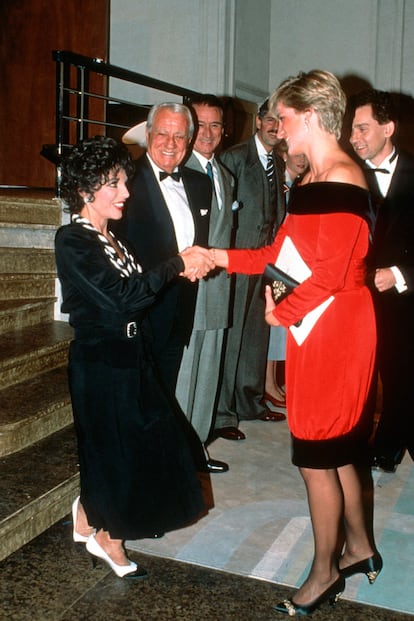 En esta imagen de 1990 está saludando a Joan Collins, que le hace la reverancia obligada. Diana vuelve a ser la reina del coordinado: rojo, blanco y negro por doquier.