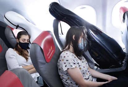 Las violonchelistas españolas Sara García y Cecilia Camón descansan durante el vuelo Madrid-Tenerife, junto a sus instrumentos.