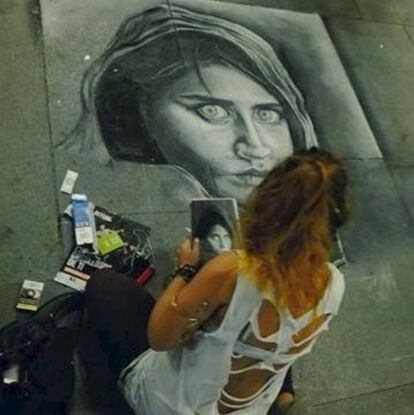 Lidija Milacic pinta un dibujo de la famosa "niña afgana", portada de National Geographic en junio de 1985, en las calles de Sevilla.