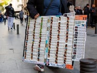Un vendedor de loterías junto a la larga colas en la administración de lotería 'Doña Manolita' en el centro de Madrid.