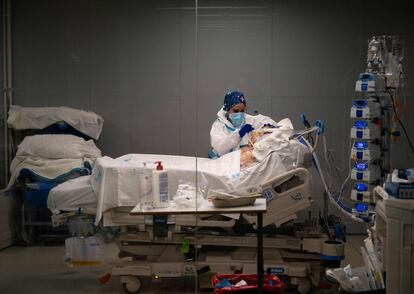 Una sanitaria atiende a un paciente en el hospital de emergencias Isabel Zendal.