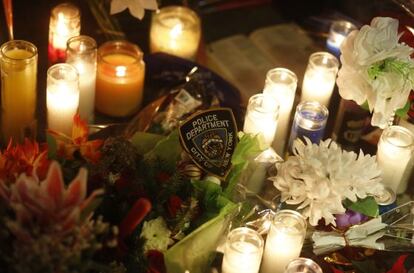 Flores y velas recuerdan a los polic&iacute;as muertos en el lugar donde fueron tiroteados en Brooklyn