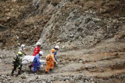 Organismos de rescate cargan los primeros restos humanos hallados de los mineros sepultados tras un derrumbe en una mina de oro que funcionaba ilegalmente en la zona aurífera de la vereda San Antonio, zona rural del municipio de Santander de Quilichao, en Cauca (Colombia).