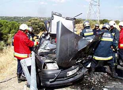 Los bomberos trabajan en el rescate de los heridos en el accidente de tráfico ocurrido ayer cerca de Boadilla del Monte.