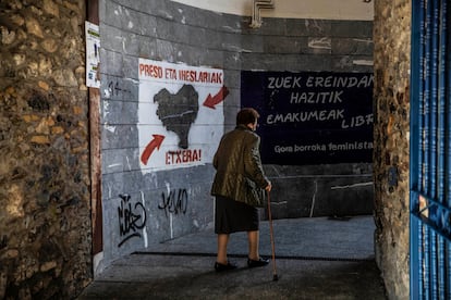 Una mujer camina junto a un cartel que reclama el acercamiento de presos de ETA, en Hernani (Gipuzkoa).