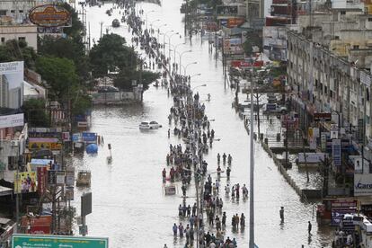 Gente caminando por el centro de una calle en la ciudad india de Chennai, afectada por las mayores inundaciones en cien años.