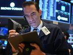 Traders work during the opening bell at the New York Stock Exchange (NYSE) on March 19, 2020 at Wall Street in New York City. - Wall Street stocks fell again early Thursday as central banks unveiled new stimulus measures and US jobless claims showed an initial hit from the slowdown generated by the coronavirus outbreak. (Photo by Johannes EISELE / AFP)