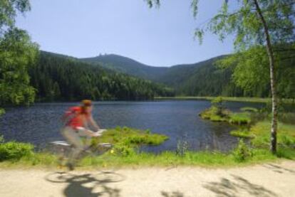 Una ciclista frente al lago Kleiner Arbersee, en el parque nacional de los Bosques Bávaros, en Alemania.