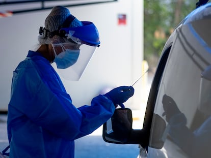 Personal sanitario toma muestras a usuarios, en su propio vehículo, para el test PCR y análisis de coronavirus en el hospital militar de Sevilla.