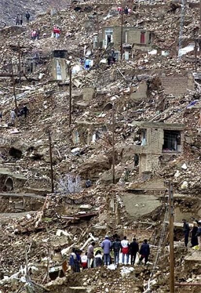 Equipos de rescate tratan de sacar a una persona sepultada por el terremoto en la aldea iraní de Hotkan.