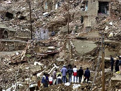 Equipos de rescate tratan de sacar a una persona sepultada por el terremoto en la aldea iraní de Hotkan.