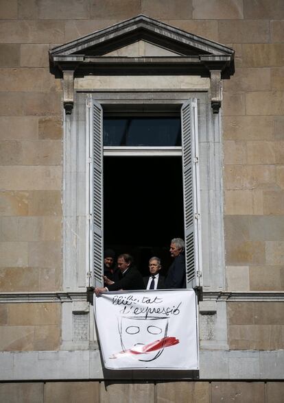 Treballadors de la Generalitat col·loquen en una finestra un altre cartell amb la frase: "Llibertat d'expressió".