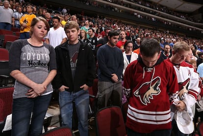 Varios de los asistentes al partido del NHL entre los Coyotes de Phoenix y los San Jose Sharks guardan un minuto de silencio por las v&iacute;ctimas del marat&oacute;n de Boston.