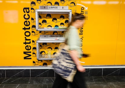 Una mujer camina el pasado lunes frente a una de las estanterías de canje de libros instaladas en el Metro de Madrid.