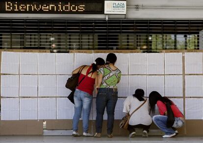 Un grupo de mujeres busca su puesto de votación en Medellín.