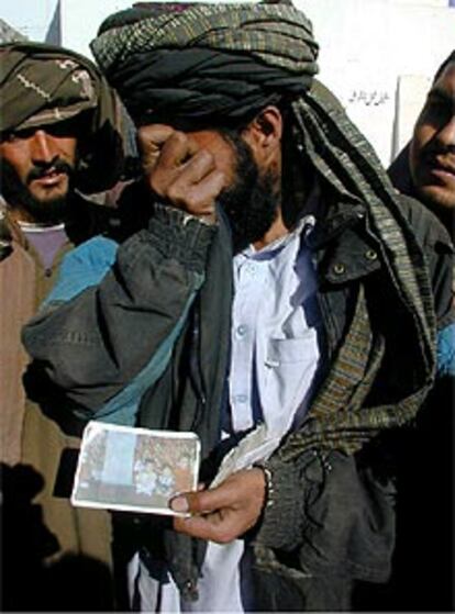 Abdul Sabar, preso de los talibanes recién liberado en Kandahar, llora al mirar una foto de sus hijos.