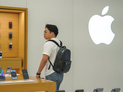 Un cliente camina por la tienda de Apple, en Pekín.