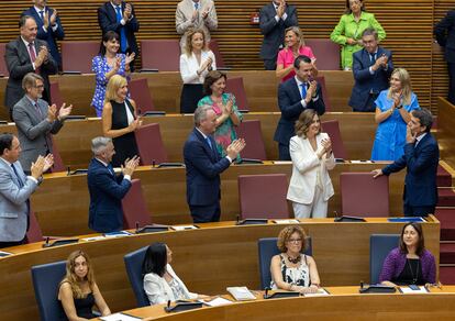 Los diputados del PP aplauden a Carlos Mazón, tras su discurso, al contrario que los aún miembros del Consell del PSPV-PSOE, Compromís y Unides Podem, este lunes en Les Corts.