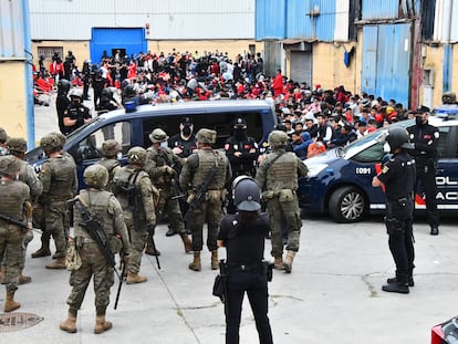 Agentes de la Policía Nacional y miembros del Ejército custodian a los inmigrantes que están en las naves del Tarajal, el martes.