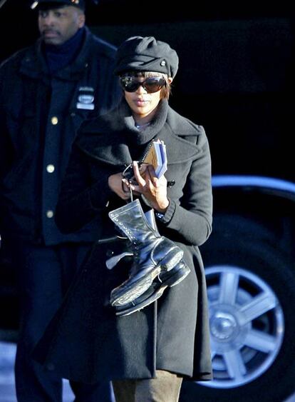 Naomi Campbell lleva entre sus manos las botas de trabajo.