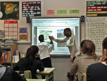 Una profesora imparte clase con una pizarra digital en el colegio público de Valencia.