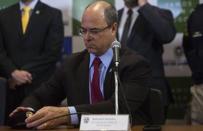 Wilson Witzel inicia coletiva de imprensa nesta terça colocando boina do BOPE sobre a mesa.