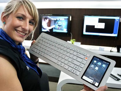 Una azafata muestra el ordenador teclado de Asus en la feria CeBit de Hannover.