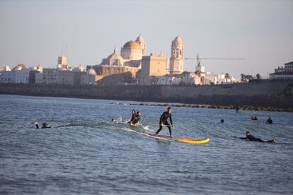 Varios deportistas practican surf en la playa de Santa María del Mar de Cádiz. Desde el 2 de mayo, las personas mayores de 14 años pueden ir a pasear y hacer deporte individual, respetando unos horarios y la distancia de seguridad, unas salidas que se suman a los paseos de los niños que comenzaron a estar permitidos una semana antes.