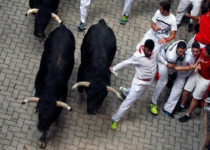 Un corredor evita el cuerno de un toro de Victoriano del Río durante el sexto encierro.