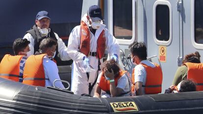 Agentes de la Fuerza Fronteriza del Reino Unido ayudan a dos niños migrantes, en el puerto de Denver (Inglaterra), el 11 de agosto.