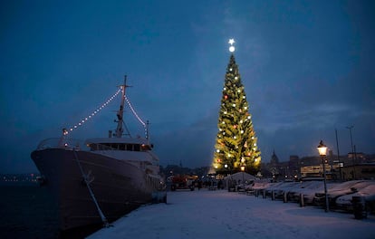 Un gran árbol de navidad ilumina el puerto de Estocolmo (Suecia), el 27 de noviembre de 201. Las luces de un árbol de navidad iluminaThe lights of Stockholm's biggest Christmas tree are switched on for the first time during Advent Sunday on November 27, 2016 in Stockholm. / AFP PHOTO /