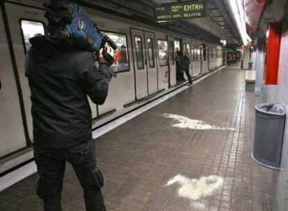 Un cámara de televisión graba imágenes de la estación del Metro de Barcelona donde un hombre fue arrollado mortalmente por un convoy tras ser empujado a la vía.
