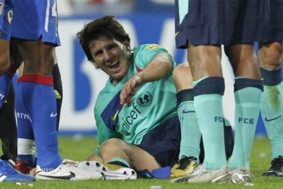 Leo Messi, entre gestos de dolor tras recibir una patada del jugador rojiblanco Ujfalusi.