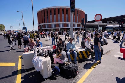 Viajeros esperan en el exterior de la estación de Atocha de Madrid, este lunes.