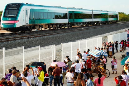 Personas miran el Tren Maya viajar durante un recorrido de prueba entre Campeche y Mérida, el 1 de septiembre.