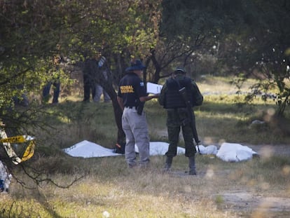 Policiais nas fossas em La Barca (Jalisco), ao lado do cemitério local.