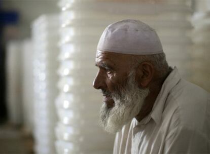 Un hombre descansa frente a varias urnas vacías en Afganistán.