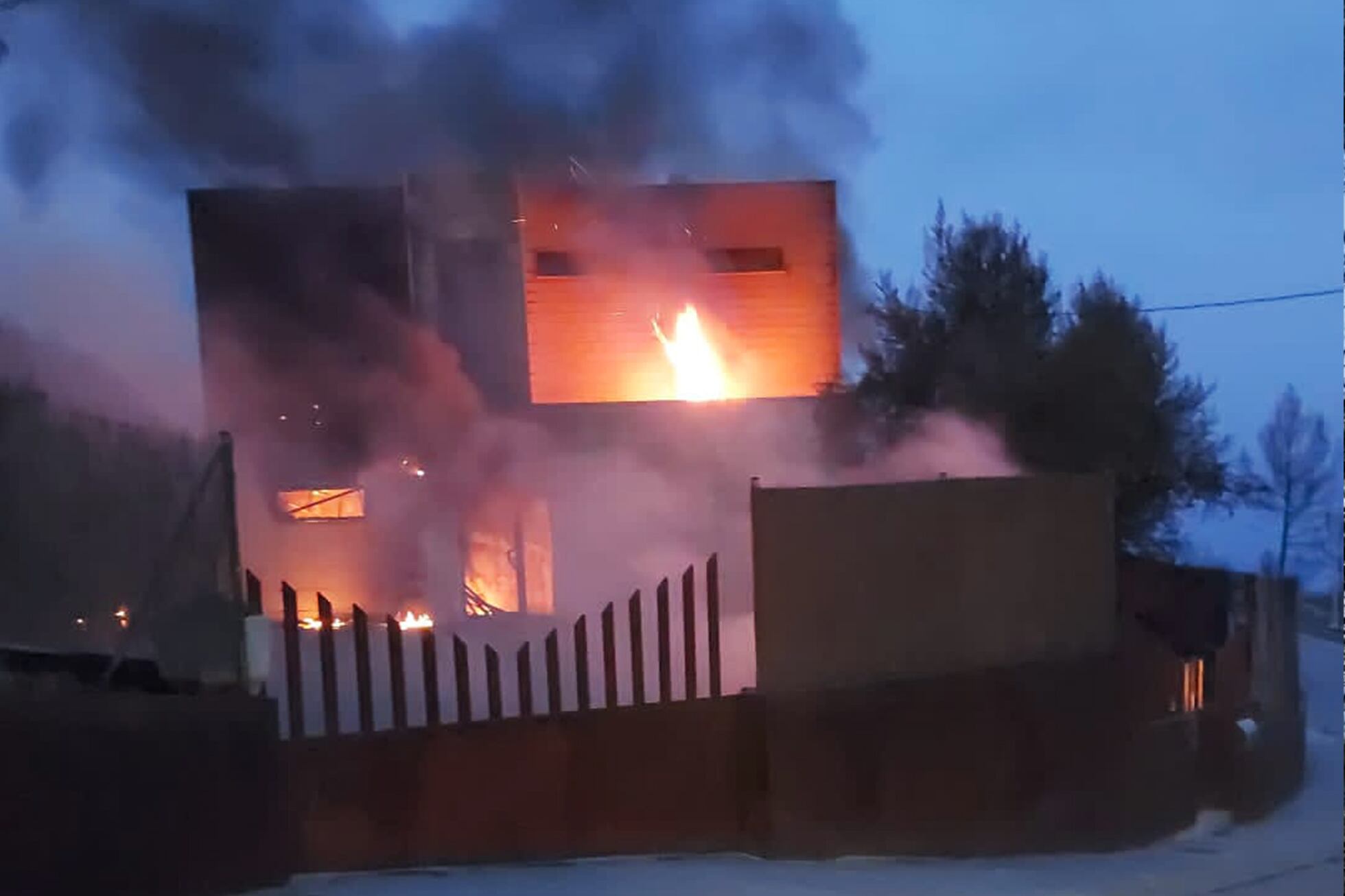 Fotografía enviada al grupo de WhatsApp vecinal con la casa de Alex Codonyer en llamas.