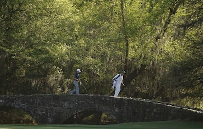 Jordan Spieth y su caddie pasan por un puente en Amen Corner.