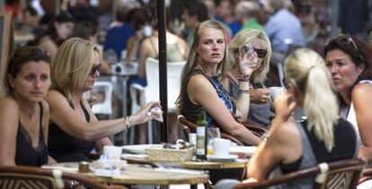 Varios turistas se refrescan en una terraza junto a La Lonja de Valencia la pasada semana.