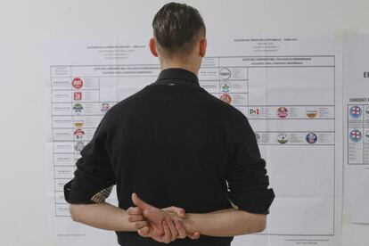Un hombre observa una papeleta con los partidos que concurren a las elecciones en un centro electoral de Fiuggi.